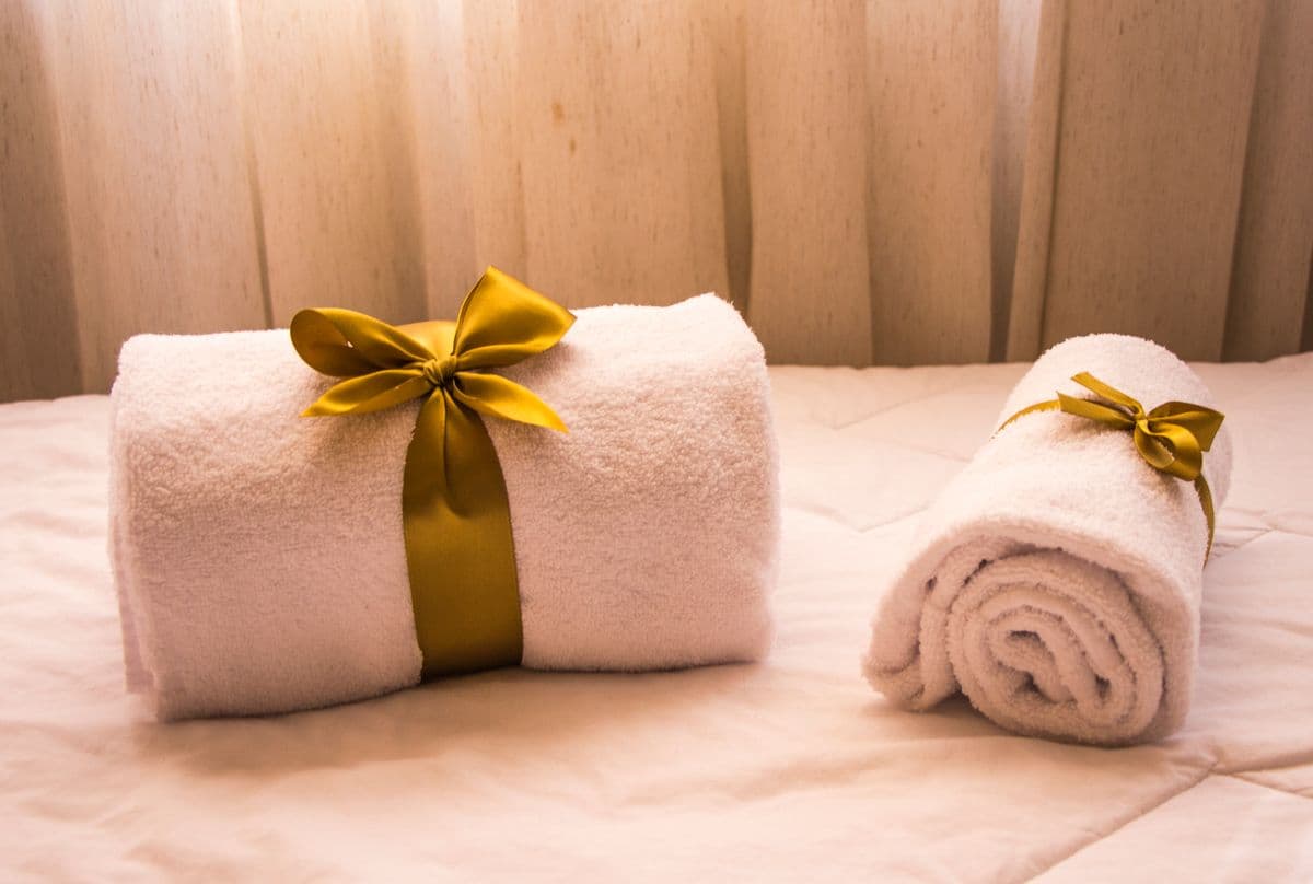 Weiße Handtücher mit goldener Schleife als Geschenk